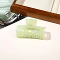 Close-up of light green pearlescent hair claw clip with a hollow square design - PVC 7.5cm Rectangular - Iridescent Green