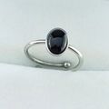 Detailed close-up of an oval black gemstone set on an adjustable silver metal ring band - 6x8mm Oval - Black Agate