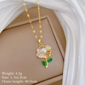 Dettaglio pendente a fiore con perla e pietre verdi su collana a catena dorata - Collana (P531)