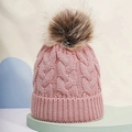 Close-up of pink cable knit beanie with a large faux fur pompom on green stand - One Size / Deep Pink