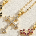 Dettaglio della collana con ciondolo a croce e zirconi colorati placcata in oro - Zirconia Bianca