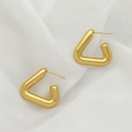 Detailed close-up of golden triangular hoop earrings on elegant white draped fabric - Triangle Stud Style (XL1464-31)