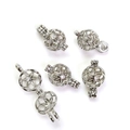 Close-up of silver hollow sphere pendant cage accessories for DIY jewelry making - White Gold