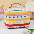Borsa da trucco a righe in cotone trapuntato con manico in un ambiente accogliente - Strisce Arcobaleno