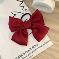 Elegant large red satin bow hair clip with elastic band shown on a wooden background - Hair Tie / Burgundy