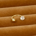 Vue macro d'un piercing d'oreille en U doré avec zircon clair sur velours marron - Style Griffes en U (Y20370-23)