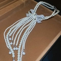 Dettaglio della collana di perle a più strati con ciondolo a fiocco e lunghe nappe - Stile Collana Lunga Con Nappa a Fiocco / Bianco
