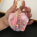 Detail of pink pompom keychain with transparent resin letter W and colorful heart sequins - Letter W