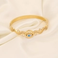 Makro-Detail des goldenen Evil-Eye-Armreifens mit blauem Inlay und Zirkonia auf Satin - Blaue Wimpern Böser Blick Stil (5#)