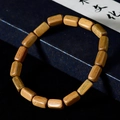 Artistic close-up of natural dark sandalwood barrel beads bracelet on calligraphy paper - Green Sandalwood Irregular Single Loop