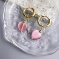 Dettaglio di orecchini a cuore placcati oro 18K con pietra occhio di gatto rosa su vassoio - Cuore Rosa