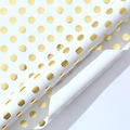 White gift wrapping paper featuring golden foil polka dots in a rolled presentation - White Base Gold Polka Dots
