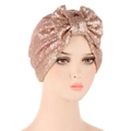 Detail of rose gold sequin turban hat featuring a large 3D bow on a mannequin head - Champagne