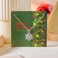 Collier flocon de neige argenté avec cristaux sur une carte cadeau de Joyeux Noël - Flocon de Neige d'Argent