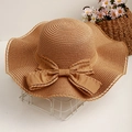 Women's summer straw sun hat with elegant wavy brim and large decorative bow detail - One Size / Caramel color
