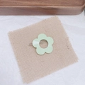 Détail d'une pince à cheveux fleur vert menthe sur lin beige avec un fond en bois naturel - Vert Herbe