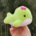 Close-up of a cute lime green whale plush toy keychain with a small pink flower - 10cm / Green