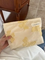 Cream satin makeup bag with yellow butterfly embroidery and white logo label - Champagne Bowknot