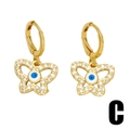 Golden butterfly hoop earrings with sparkling rhinestones and Evil Eye center detail - Butterfly Evil Eye Style / Gold