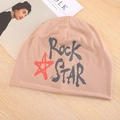 Detail van de gebreide khaki muts met rode ster en zwarte Rock Star print op hout - Eén Maat (55-59cm) / Khaki