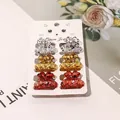Close-up of six mini resin hair claws with black speckles on a cute cat display card - Speckled Pumpkin