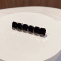 Dettaglio del fermaglio dorato con strass neri rettangolari su un vassoio bianco - Quadrato / Nero Quadrato