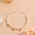 Detail of natural white shell necklace with gold starfish and dolphin charms on beige base - White Rope Starfish Necklace