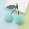 Detailed close-up of mint green cherry plush keychain with dark green leather leaf and gold clasp - Spring Ring / Mint Green