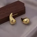 Minimalist golden teardrop stud earrings with polished finish on purple satin background - Waterdrop Studs / E-049---Gold