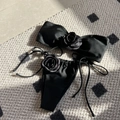 Black strapless bikini set with 3D rose details and side-tie bottoms on a plaid background - Black