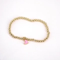 Detailed close-up of golden beaded bracelet featuring a pink enamel heart pendant charm - Pink
