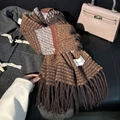 Winter plaid scarf with tassels in dark brown, orange, and grey on a wool coat - Coffee