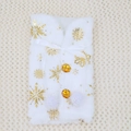 Close-up of white plush Christmas wine bottle cover with gold snowflakes and bow - Gold Snowflake