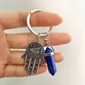 Macro view of Hamsa Hand pendant with evil eye and lapis blue crystal pillar keychain - Lapis Lazuli