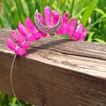 Macro detail of handmade magenta crystal crown with silver moon on a wooden fence - Rose Red Crystal with Silver Wire & Moon