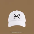 Close-up of white canvas sun hat with minimalist black butterfly embroidery detail - Front Bowknot Embroidery Baseball Cap / White