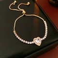 Detail of gold heart zircon bracelet with adjustable tennis chain on black background - Gold-White