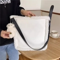 Nahaufnahme einer weißen Plüsch-Tragetasche mit Bärenanhänger auf einem gemütlichen Tisch - Weiße Plüsch-Patchwork-Tragetasche (Mit Bärenanhänger)