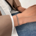 Close-up of a sleek silver snake chain bracelet worn on a wrist for a modern style - Silver Tone Snake Chain (K-770)
