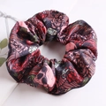 Detail of fabric scrunchie with skull, rose, and feather patterns for hair styling - Black Pink