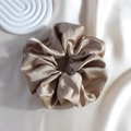 Detailed close-up of champagne silk satin scrunchie with soft glossy texture and sheen - Champagne