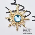 Makroaufnahme: Goldener Sonnenanhänger mit hellblauem facettiertem Harzedelstein - Transparentes Seeblau