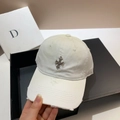 Detail einer weißen Distressed-Baseballkappe mit Metallkreuz und ausgefransten Kanten - Weiß