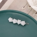 Close-up of pearl hair clip with four flower clusters on a green ceramic plate - Silver Pearl Style (B6504)