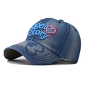 Macro shot of 3D Angel Story embroidery on washed blue denim baseball cap detail - Adjustable / Denim With Blue Text