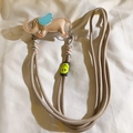 Detail of beige woven nylon phone lanyard featuring a cute elephant charm with blue wings - Back Clip + Long Strap / Milk Coffee
