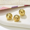 Macro shot of 8-9mm vintage golden hollow metal beads with embossed textures for DIY jewelry - Style 6