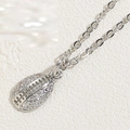 Close-up of silver rugby pendant with pavé-set clear cubic zirconia on minimalist chain - Conch Shell (XL2422) / Silver
