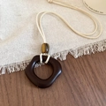 Detailed close-up of a resin square pendant on a wax cord over a linen texture - Necklace-White-Coffee-Irregular