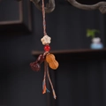 Detailed view of hand-woven cord with peanut wood carving and red agate bead charm - Peanut Prosperity Phone Chain